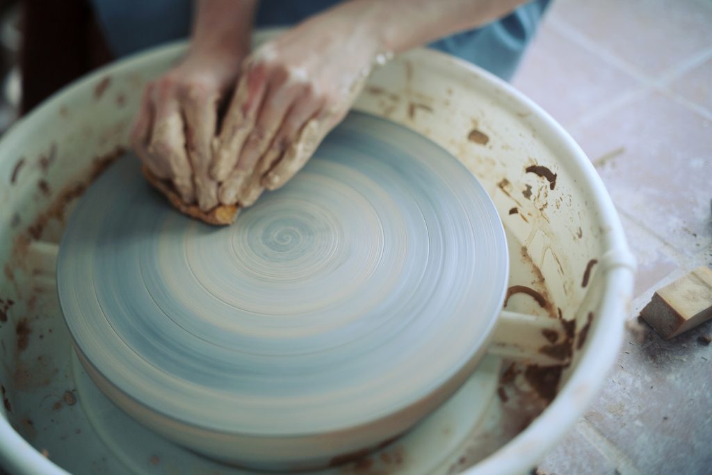 Photo de Tuan Anh NP de Chris Thibli en train de nettoyer la girelle du tour de potier.